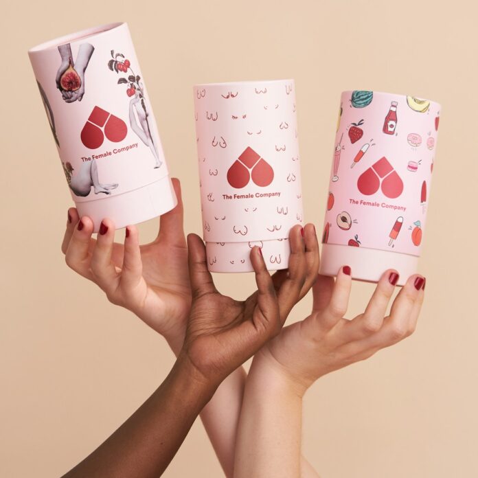 Photo by The Female Company person holding white and pink heart and hearts playing cards