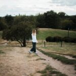 마음 건강도 챙기는 ‘마음 챙김 산책’, 일상 속 작지만 큰 변화 A person walks on a path in a grassy landscape.