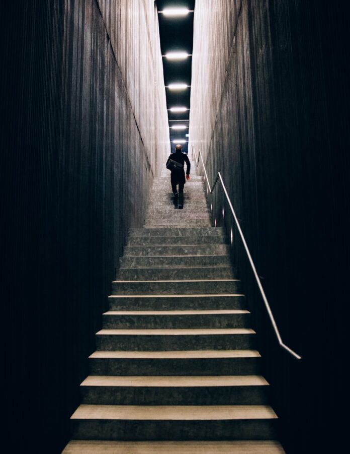 Photo by Heidi Fin man in black pants going down stairs