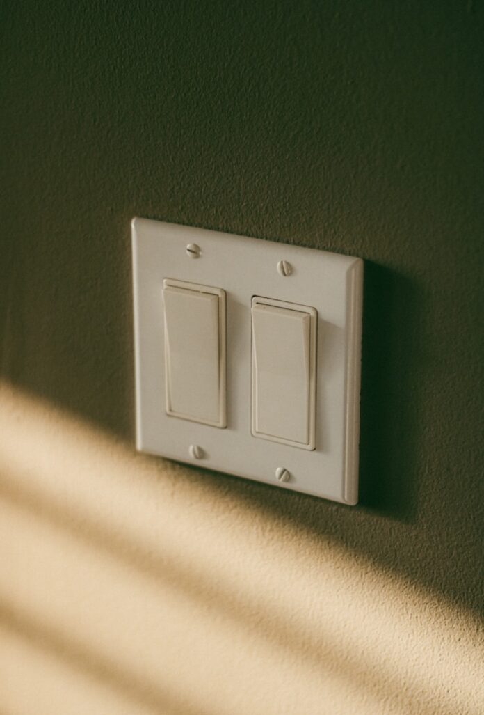 a white light switch sitting on top of a wall